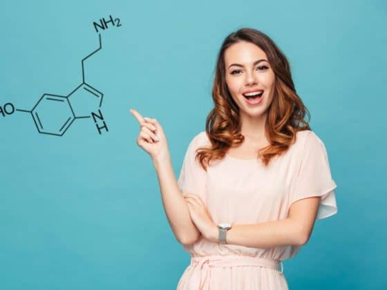 A happy woman points to a molecule of serotonin, isolated against blue background. Natural serotonin boosters concept.