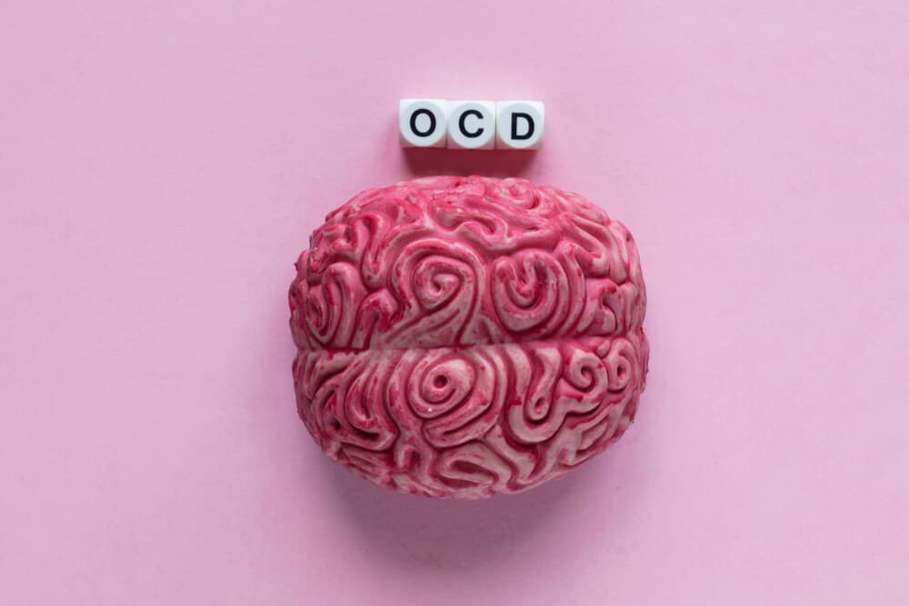 OCD vs OCPD - A pink brain with black and white letter beads spelling 